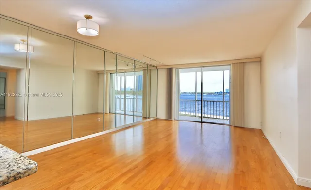 an empty room with wooden floor and a window