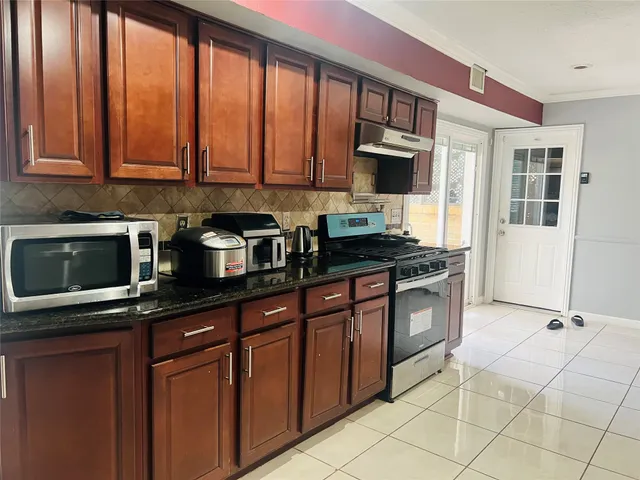 a kitchen with stainless steel appliances granite countertop a refrigerator and a stove top oven