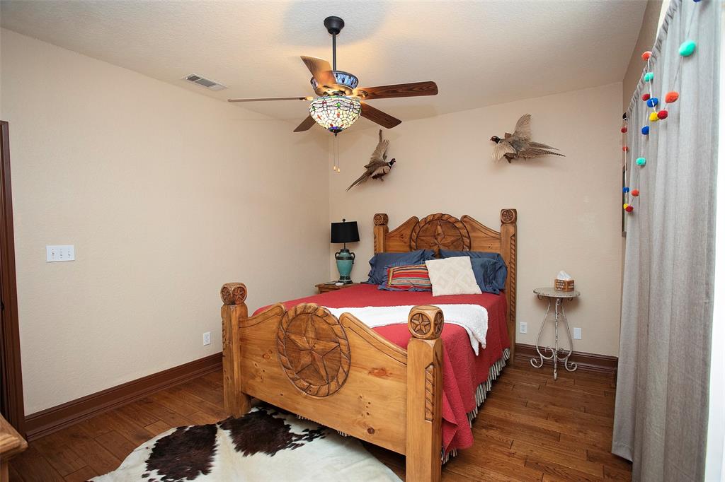 880 Cliffs Drive Graford, TX 76449 - Photo 18 of 40 a bedroom with a bed and wooden floor