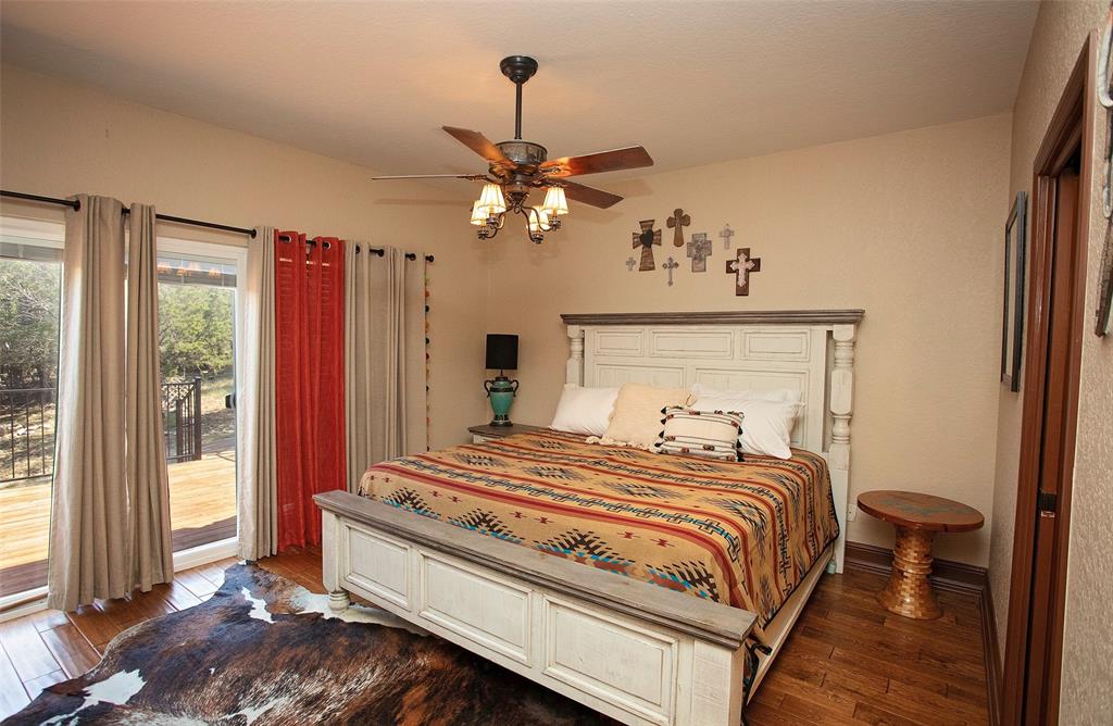 880 Cliffs Drive Graford, TX 76449 - Photo 19 of 40 a bedroom with a bed and a chandelier