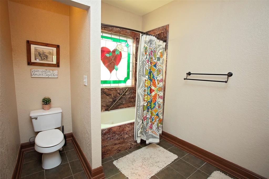 880 Cliffs Drive Graford, TX 76449 - Photo 24 of 40 a bathroom with a toilet and a shower