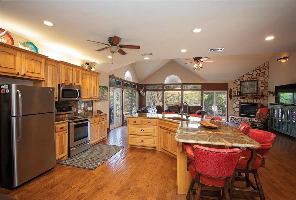880 Cliffs Drive Graford, TX 76449 - Photo 6 of 40 a large kitchen with a table chairs refrigerator and a sink