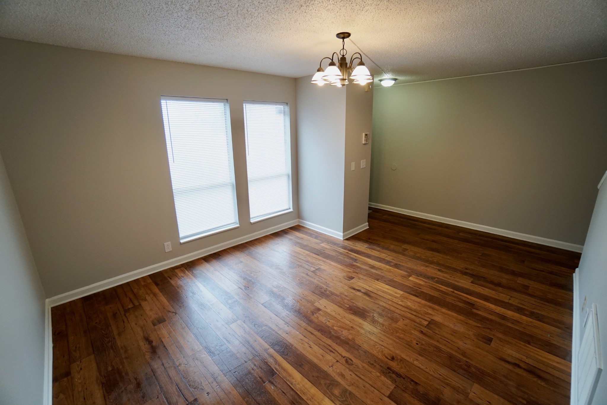 500 Paragon Mills Road, Unit B7 Nashville, TN 37211 - Photo 2 of 9 an empty room with wooden floor and chandelier