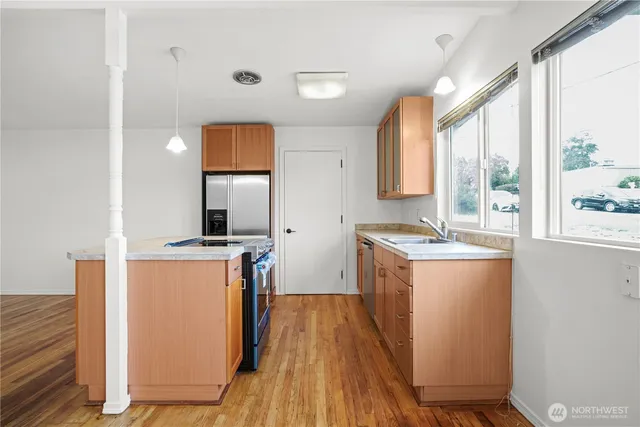 a kitchen with stainless steel appliances granite countertop a stove a sink and a refrigerator