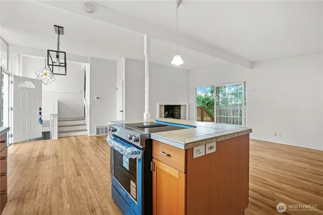 a kitchen that has a stove and a wooden floor