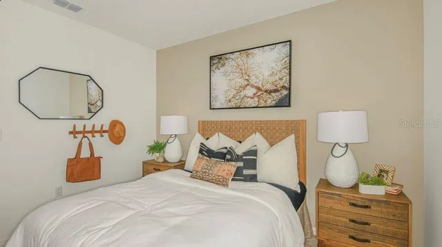 a bedroom with a bed and a lamp on dresser