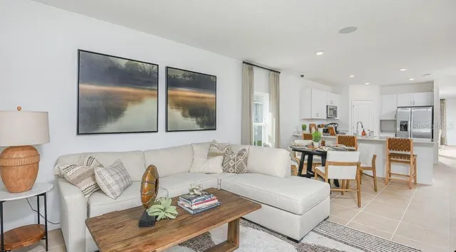a living room with furniture kitchen and a table