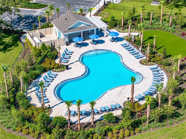 an aerial view of a house with swimming pool and outdoor seating