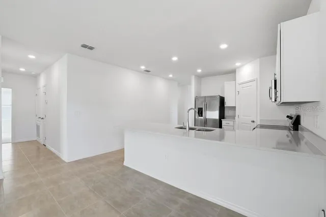 a view of kitchen with refrigerator sink and stove