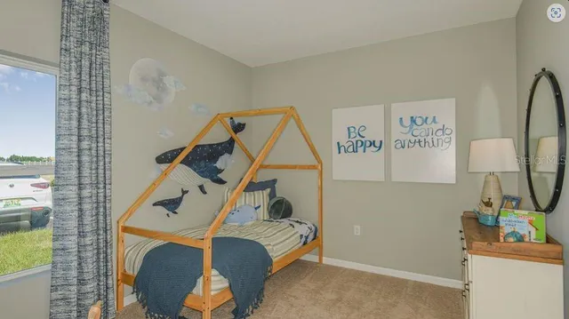 a bedroom with a bed and a flat tv screen on the wall