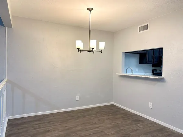 a view of a room with wooden floor and chandelier