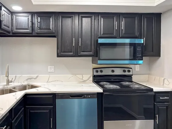 a kitchen with a sink a stove and cabinets