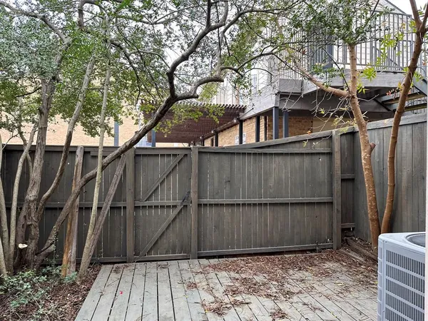 a view of backyard with wooden fence and large trees