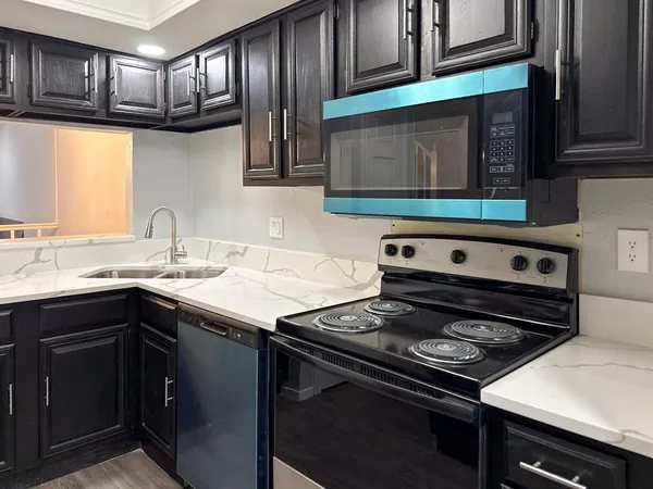 a kitchen with wooden cabinets stove top oven and sink