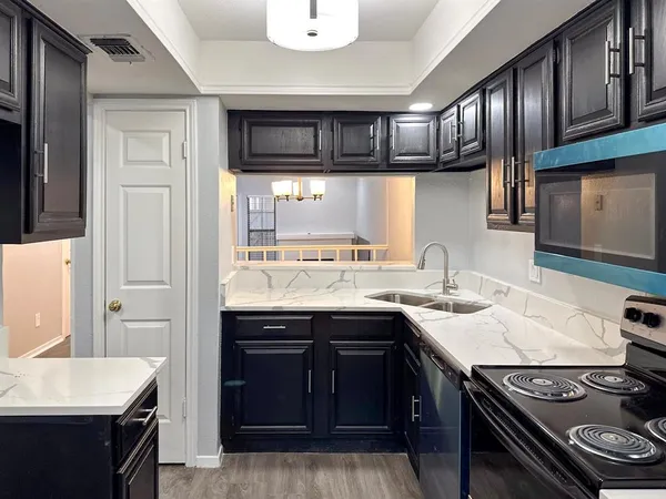 a kitchen with stainless steel appliances granite countertop a sink stove and cabinets