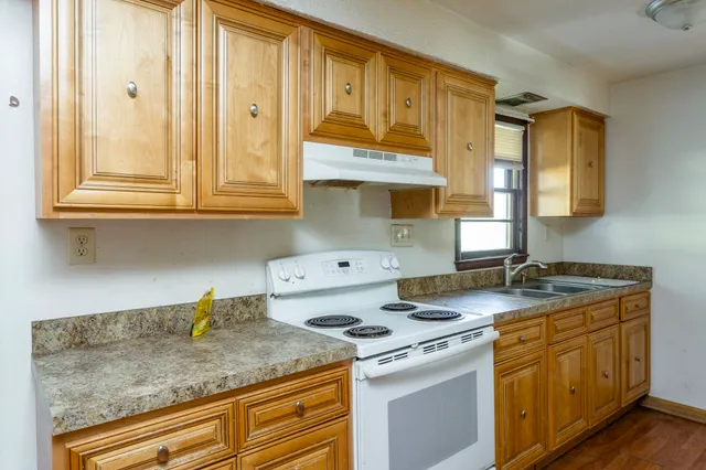 a kitchen with stainless steel appliances granite countertop a sink stove and cabinets