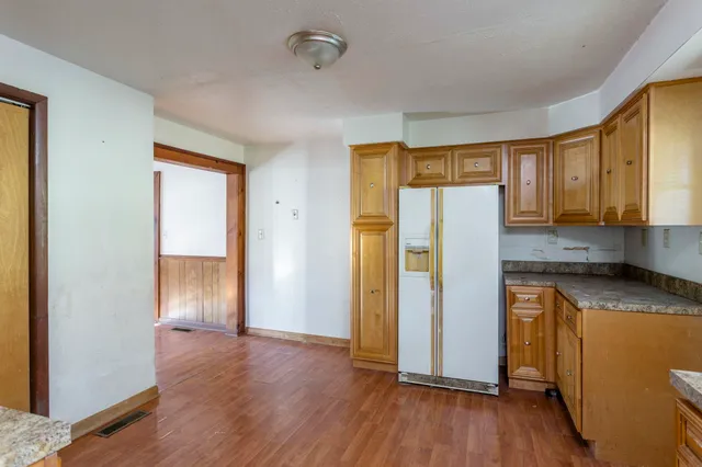a kitchen with granite countertop wooden floors and stainless steel appliances
