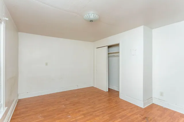 a view of empty room with wooden floor