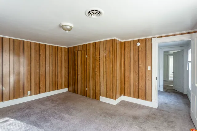 a view of a room with a ceiling fan and window