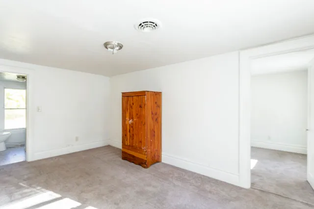 an empty room with windows and closet