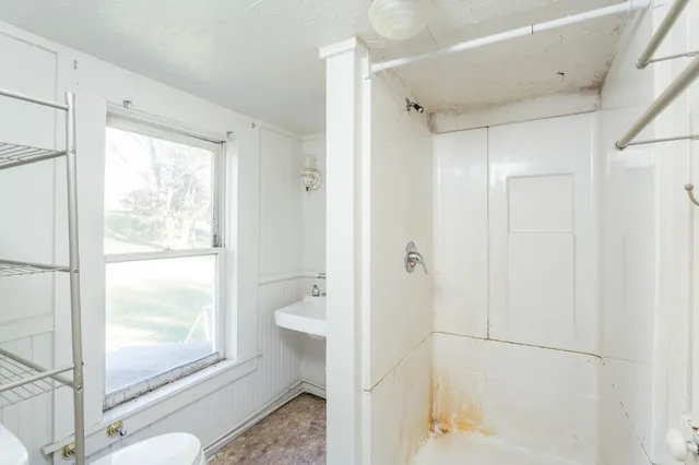 a bathroom with a sink a toilet and shower