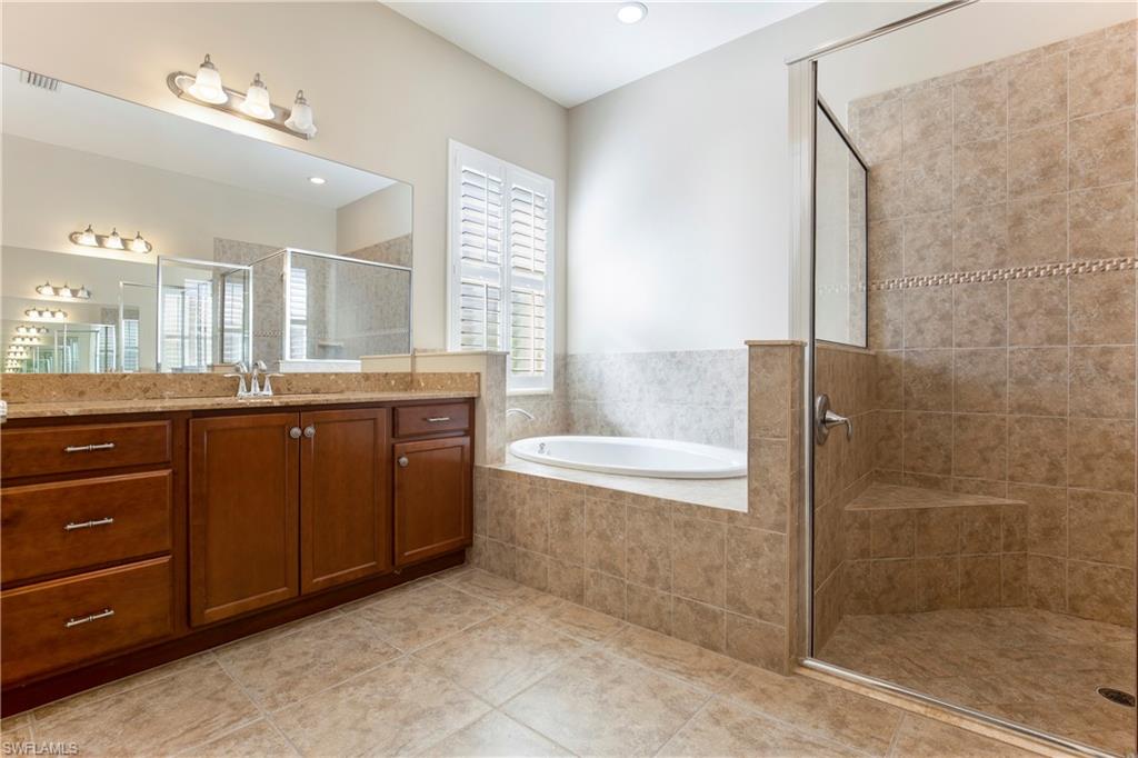 13515 Cambridge Lane Naples, FL 34109 - Photo 14 of 28 a bathroom with a granite countertop sink a toilet and a bathtub