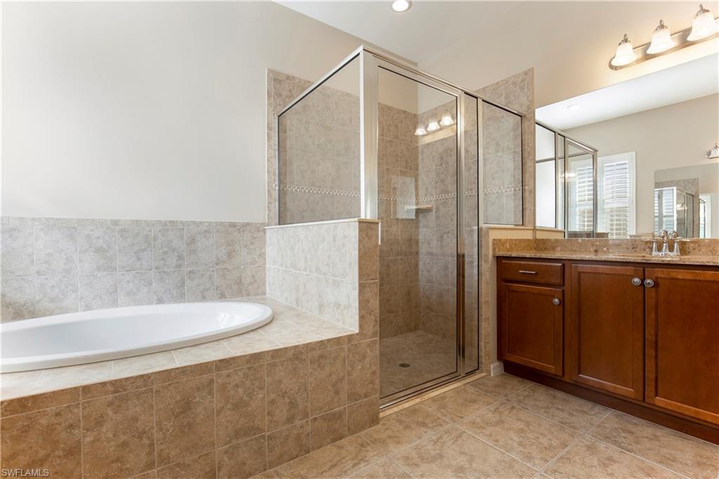 13515 Cambridge Lane Naples, FL 34109 - Photo 15 of 28 a bathroom with a granite countertop sink a toilet and shower