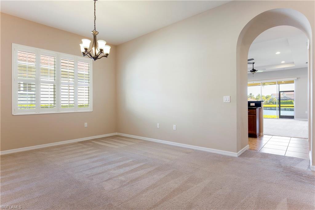 13515 Cambridge Lane Naples, FL 34109 - Photo 10 of 28 an empty room with chandelier fan and windows