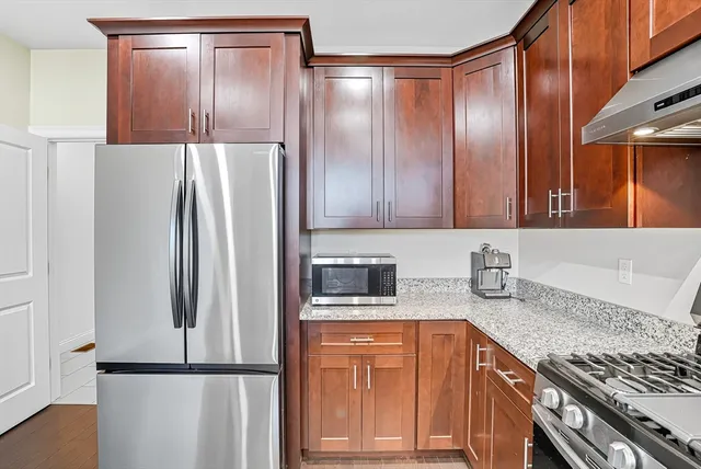 a kitchen with stainless steel appliances granite countertop a refrigerator and a sink