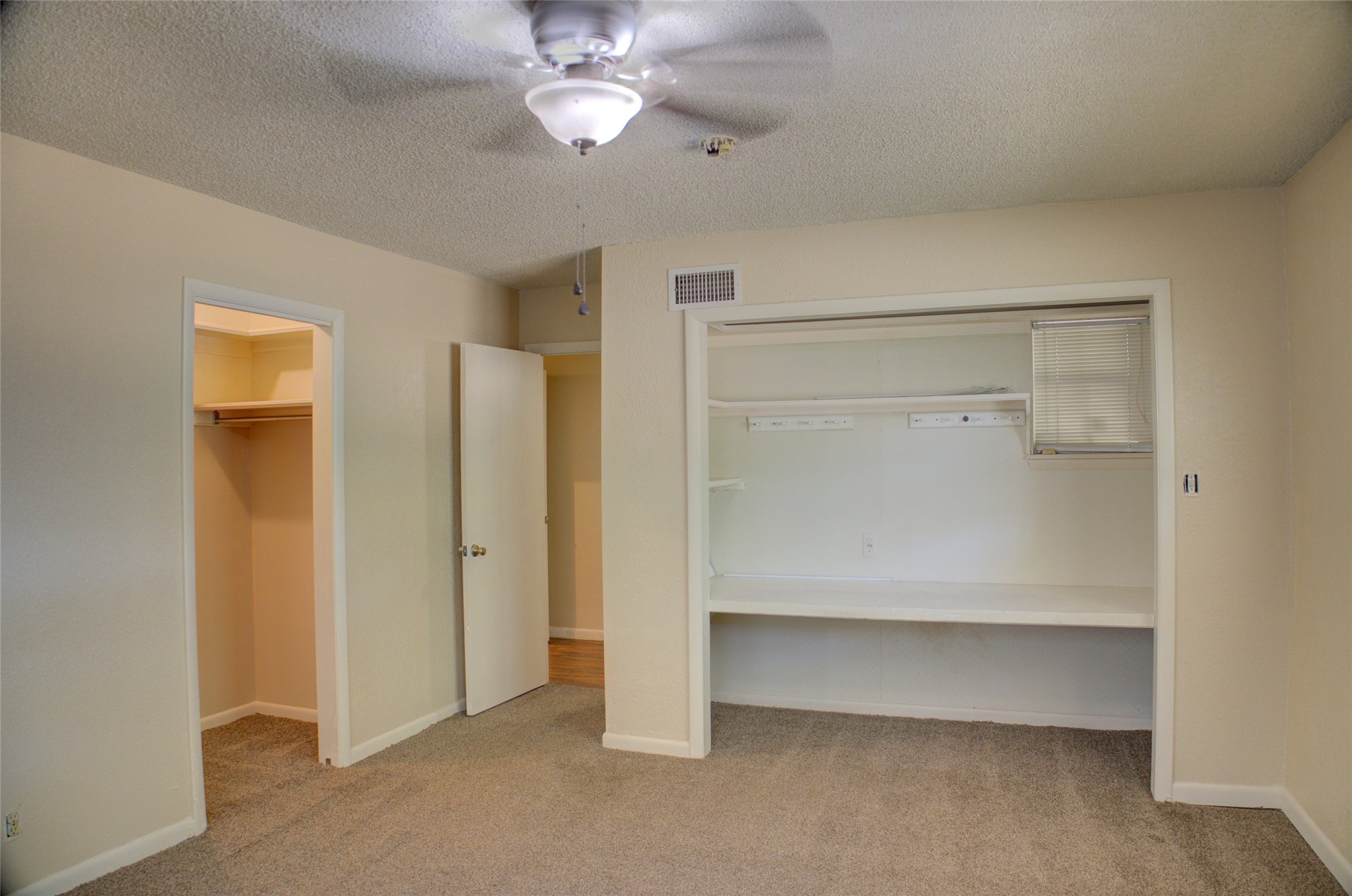 12420 South Garnett Road Broken Arrow, OK 74011 - Photo 37 of 44 Carpeted room featuring a ceiling fan with light, an open closet with built-in shelving, an additional closet with built-in shelving, and a painted interior door