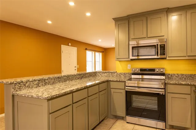 a kitchen with granite countertop cabinets stainless steel appliances and a counter space