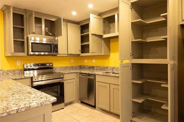 a kitchen with stainless steel appliances granite countertop a stove and a refrigerator