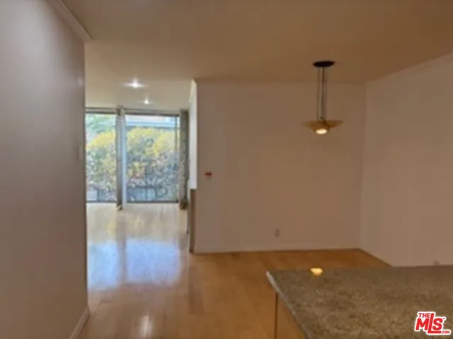 a kitchen with stainless steel appliances granite countertop a refrigerator a stove and a sink with wooden floor