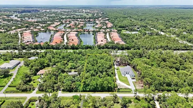 an aerial view of residential houses with outdoor space and trees