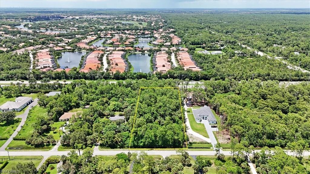 an aerial view of residential houses with outdoor space and trees