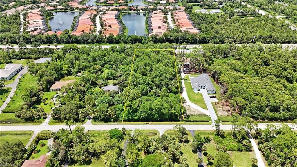 5665 Napa Woods Way Naples, FL 34116 - Photo 3 of 20 a aerial view of a house with a yard and lake view
