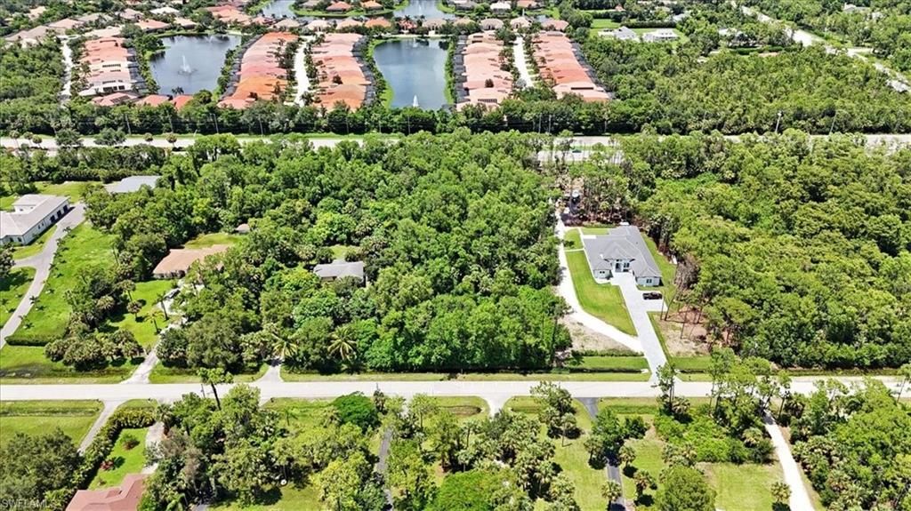 5665 Napa Woods Way Naples, FL 34116 - Photo 4 of 20 a aerial view of a house with a yard and lake view