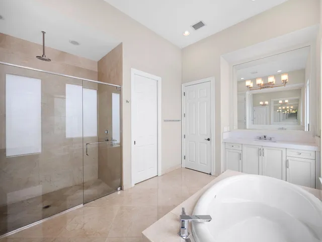 a bathroom with a tub sink shower and mirror