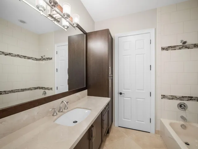 a bathroom with a tub a sink and mirror