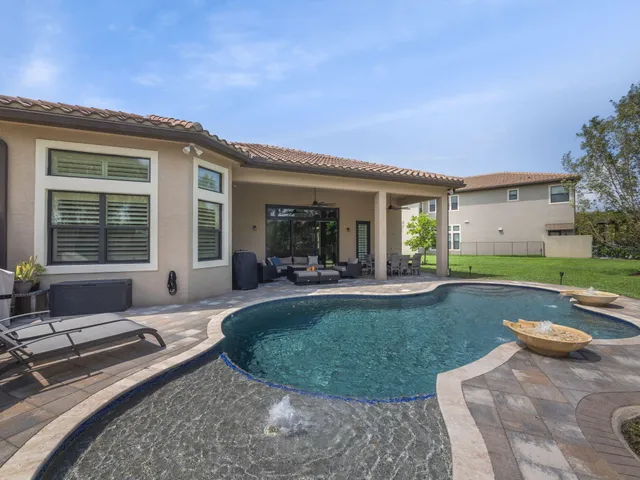 a view of a house with backyard sitting area and swimming pool