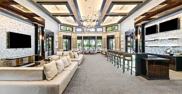 a living room with large windows and a chandelier