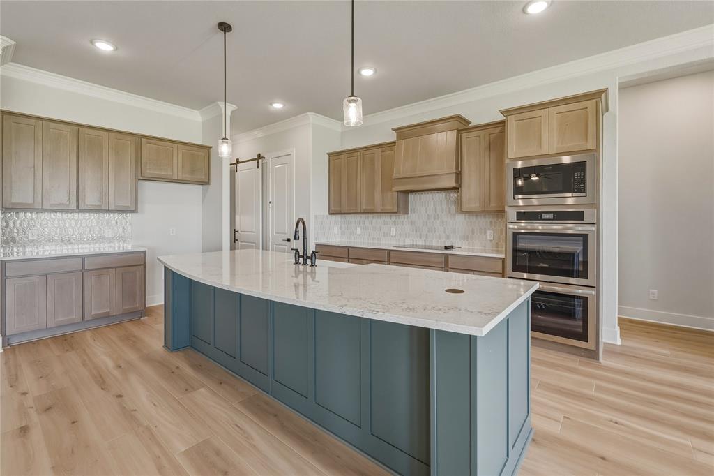 2305 Gypsum Street Krum, TX 76249 - Photo 9 of 26 Central kitchen island with a quartz countertop and integrated sink