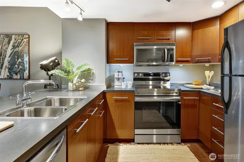 a kitchen with stainless steel appliances granite countertop a sink stove and microwave