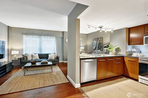 a large living room with stainless steel appliances granite countertop furniture and a wooden floor
