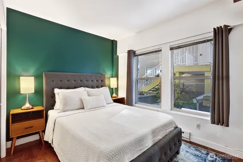 a bedroom with a bed and a large window