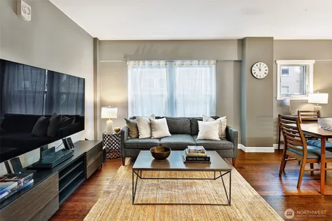 a living room with furniture a rug and a flat screen tv