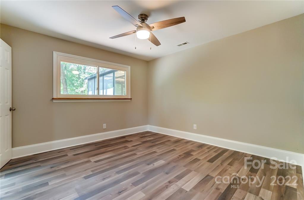 3001 Morgan Mill Road Monroe, NC 28110 - Photo 23 of 36 an empty room with wooden floor ceiling fan and windows