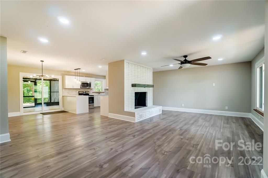 3001 Morgan Mill Road Monroe, NC 28110 - Photo 5 of 36 an empty room with wooden floor kitchen view and a window