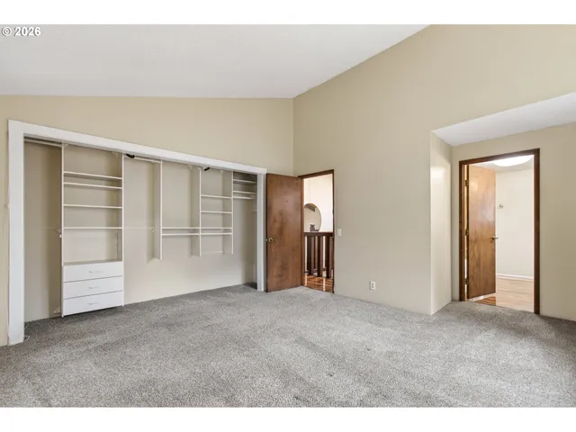 a view of an empty room with wooden floor and closet