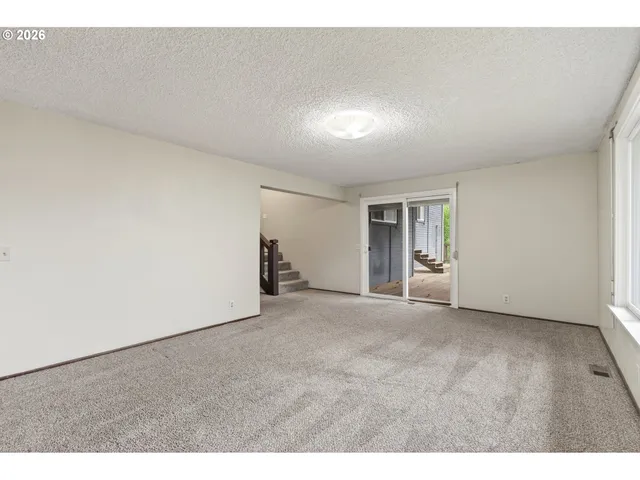 a view of an empty room with closet and a window